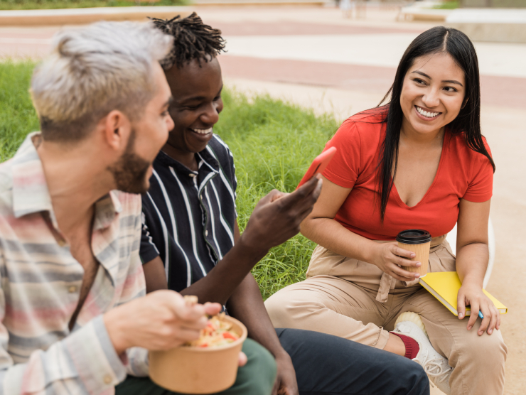 Three young people sitting outside