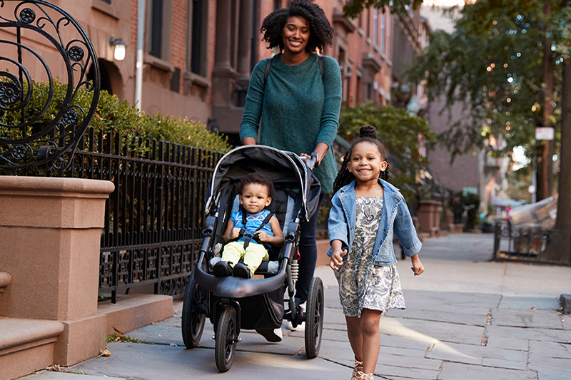 Working mom walking kids to tuition subsidies child care center