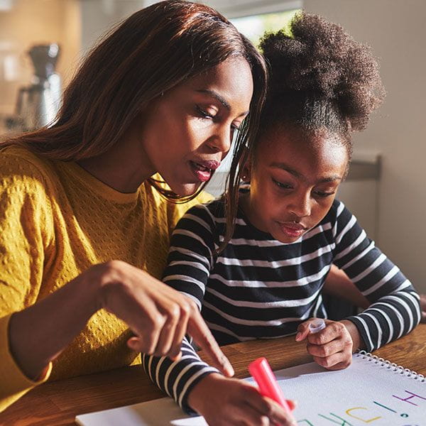 A parent helping her son with school work