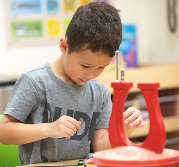 A young child learns from the educationally rich Bright Horizons curriculum at daycare