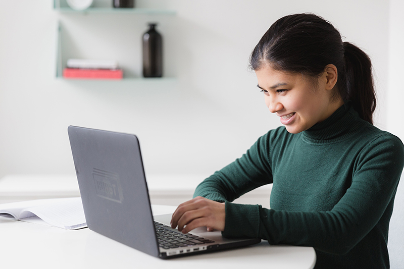 Young woman reading about PSLF limited waiver online