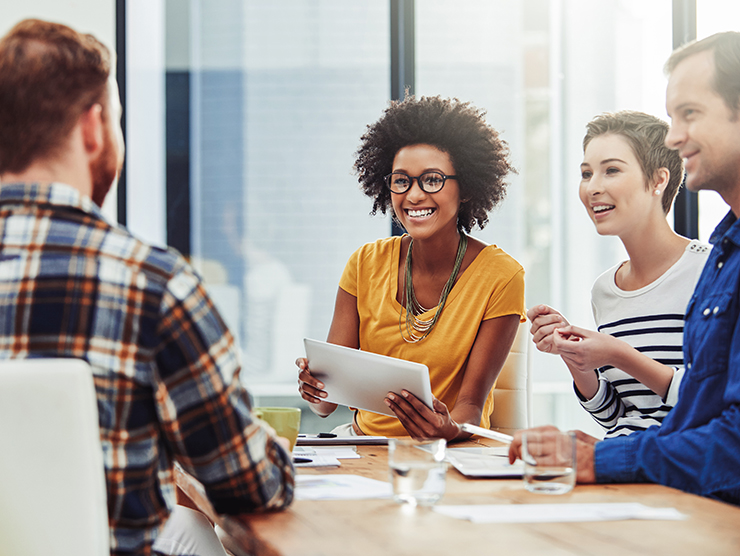 Two women and two men sitting together at office desk