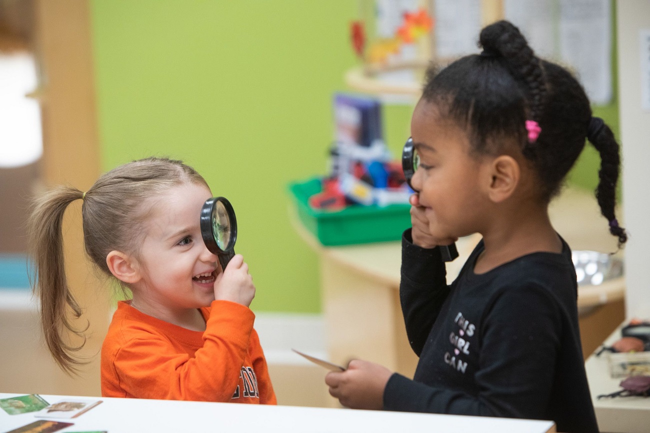 Two children playing with magnifying glasses