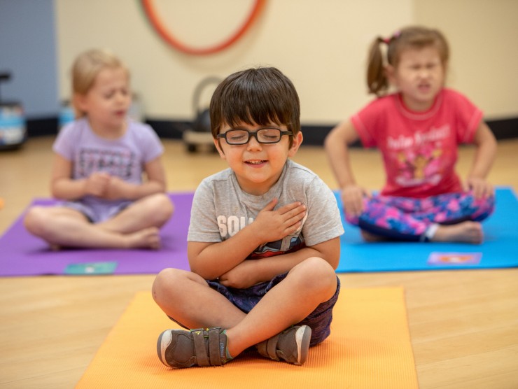 children sitting on yoga mats 