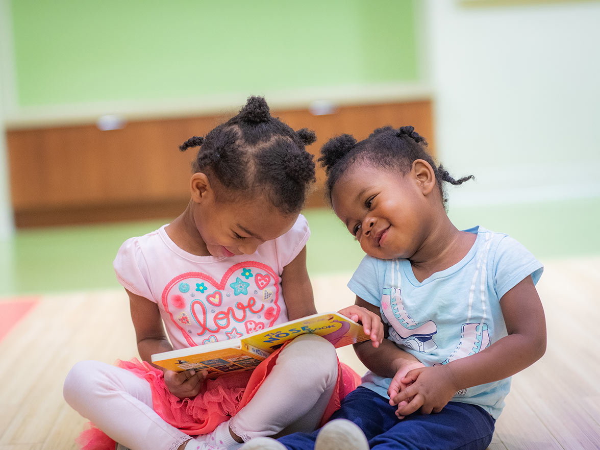 sisters reading a book happy