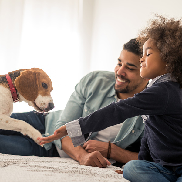 A father and daughter playing with a puppy