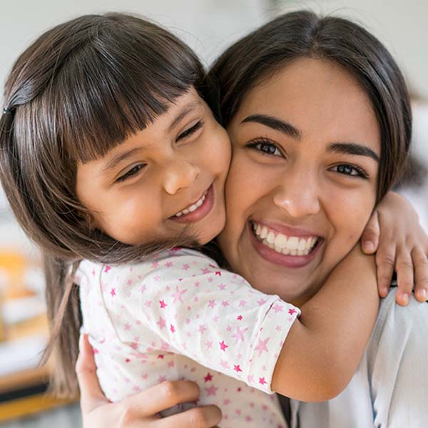 girl hugging teacher smiling