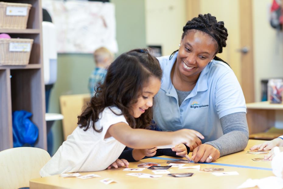 Bright Horizons teacher guiding a student through a learning activity