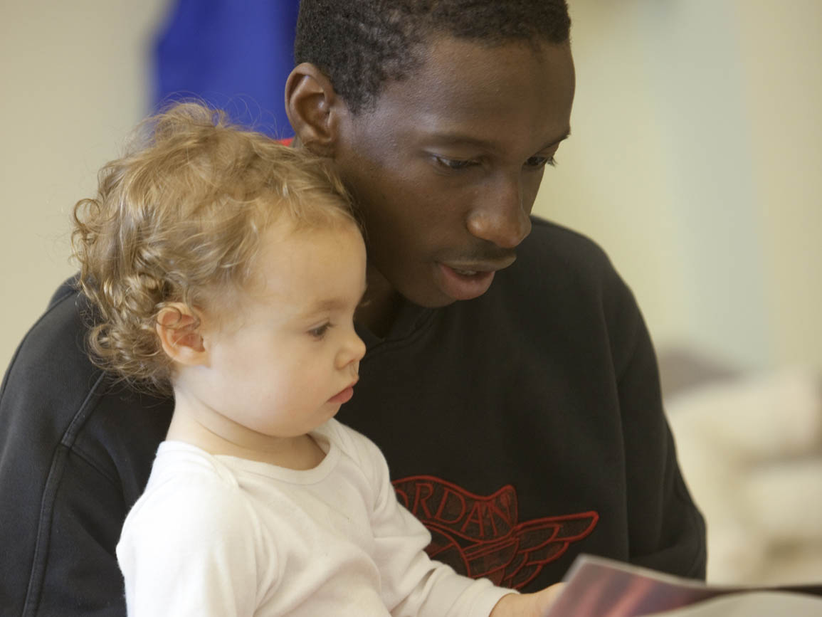 Teacher sitting and reading with a preschool aged girl