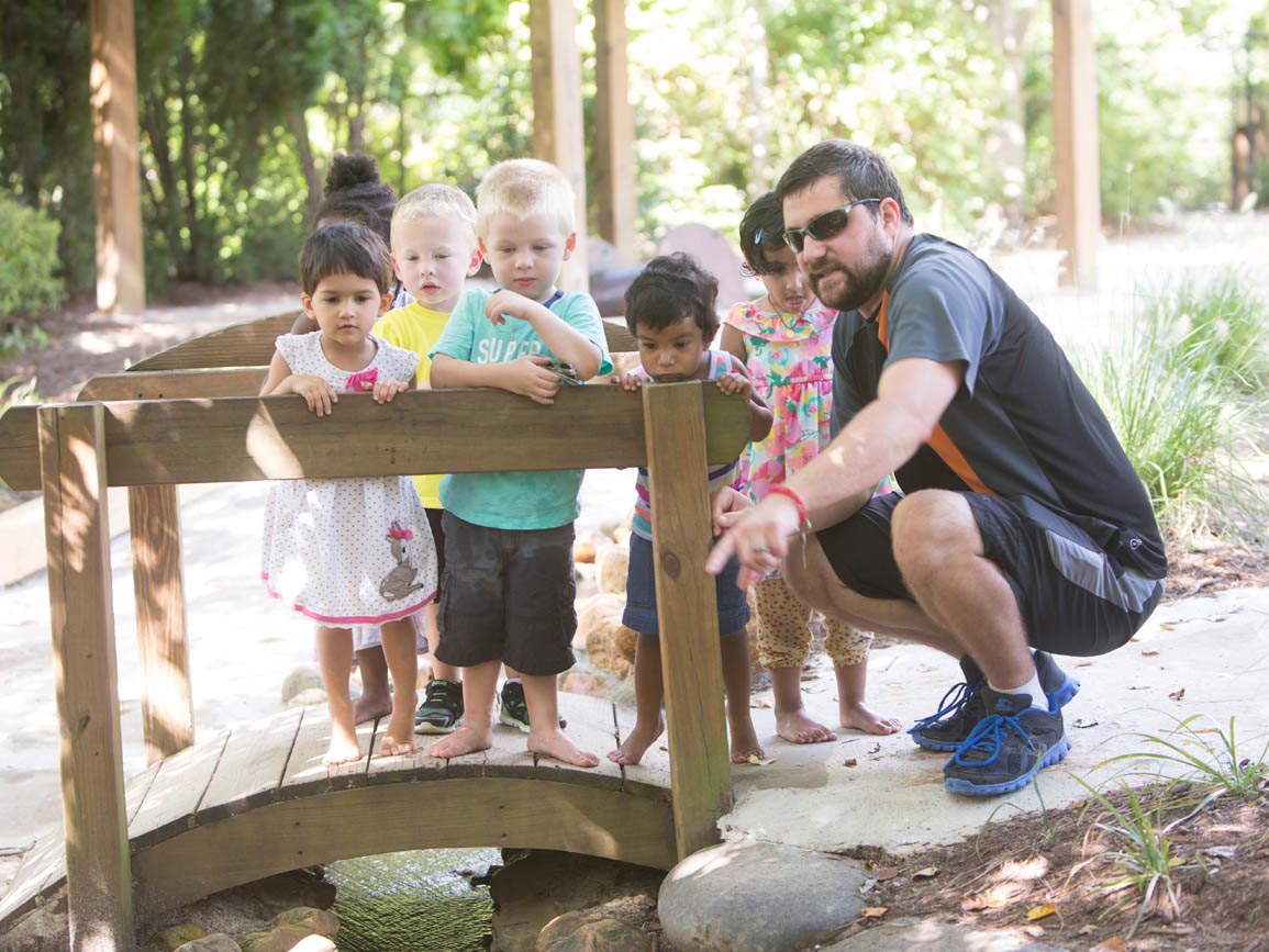 Teacher with group of young kids exploring nature