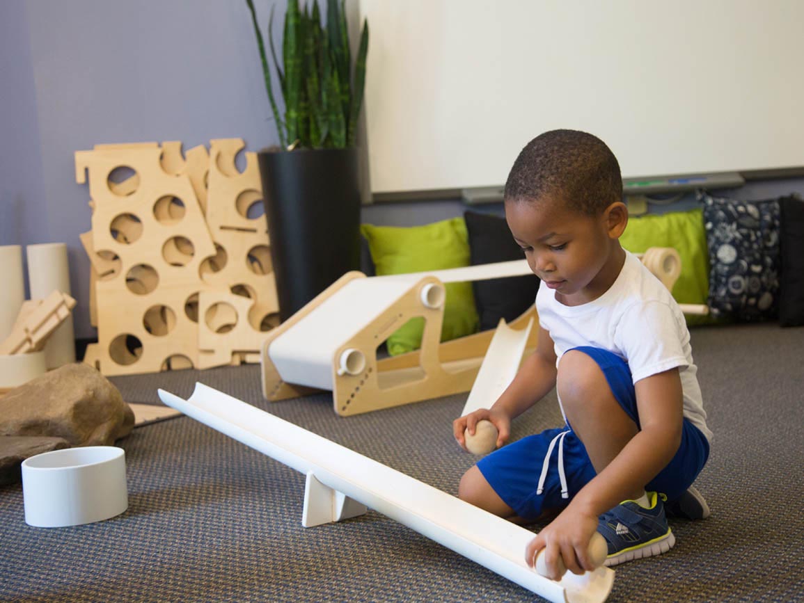 Kindergarten-aged boy building a ramp