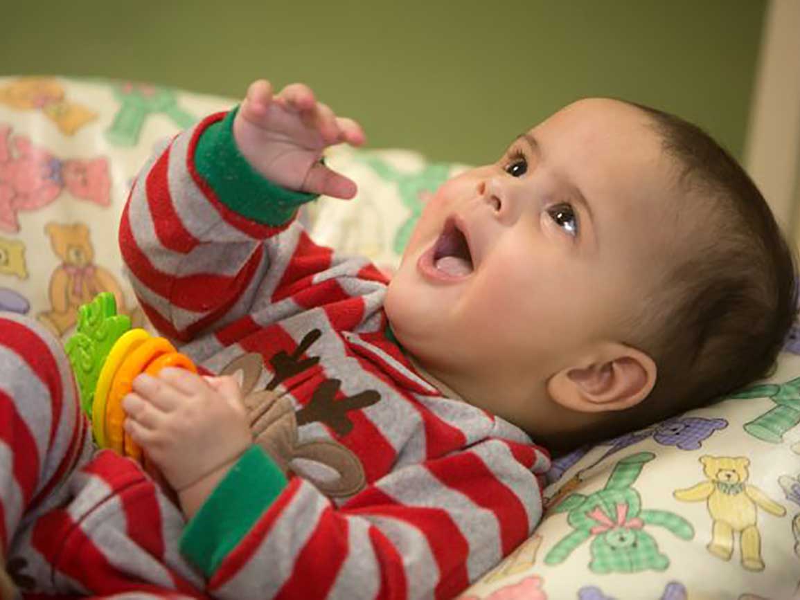 Laughing baby on a pillow