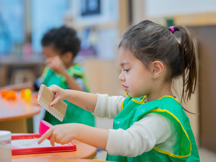 girl doing arts and crafts in a bright horizons center