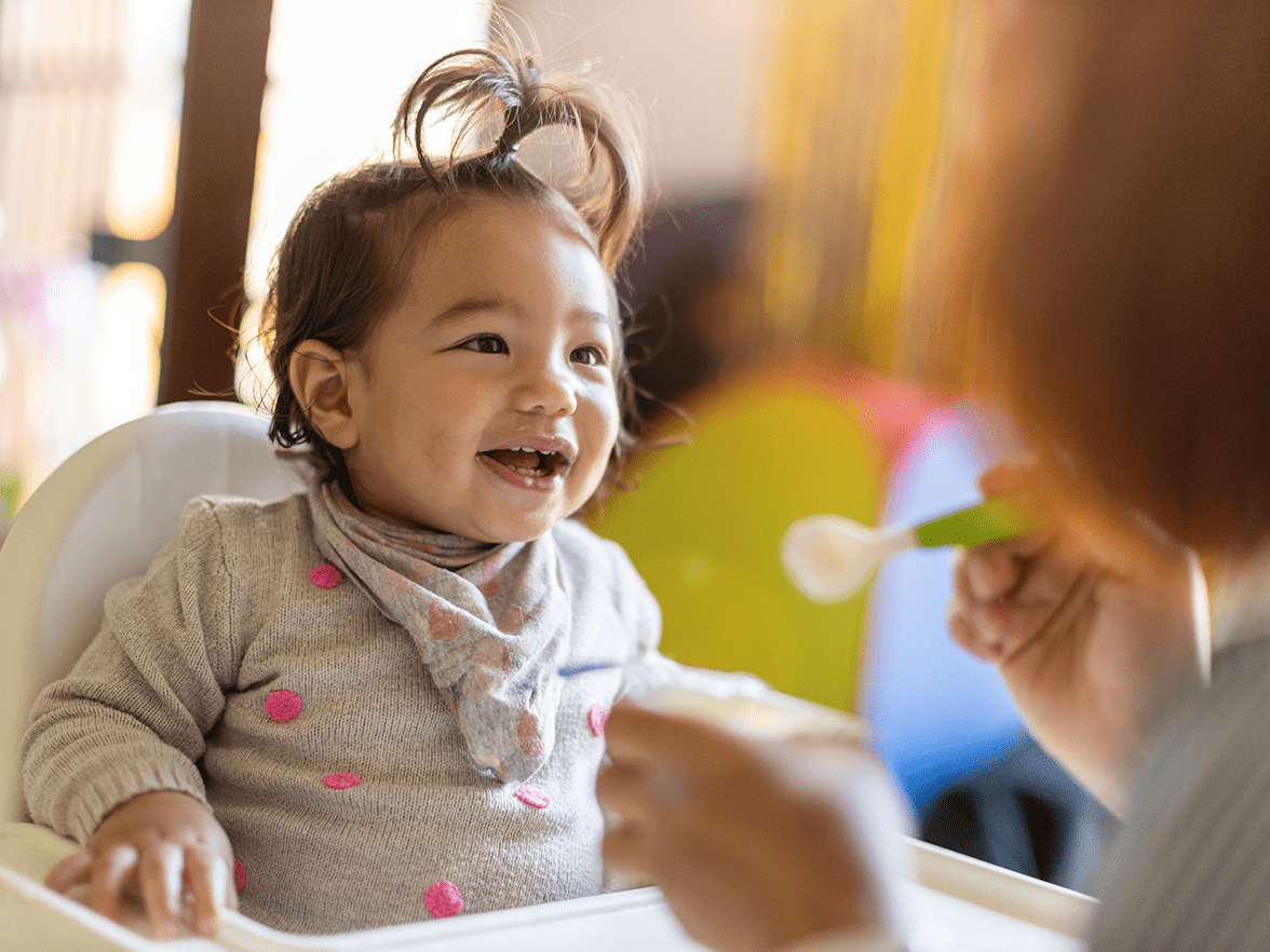 A child in a highchair being fed