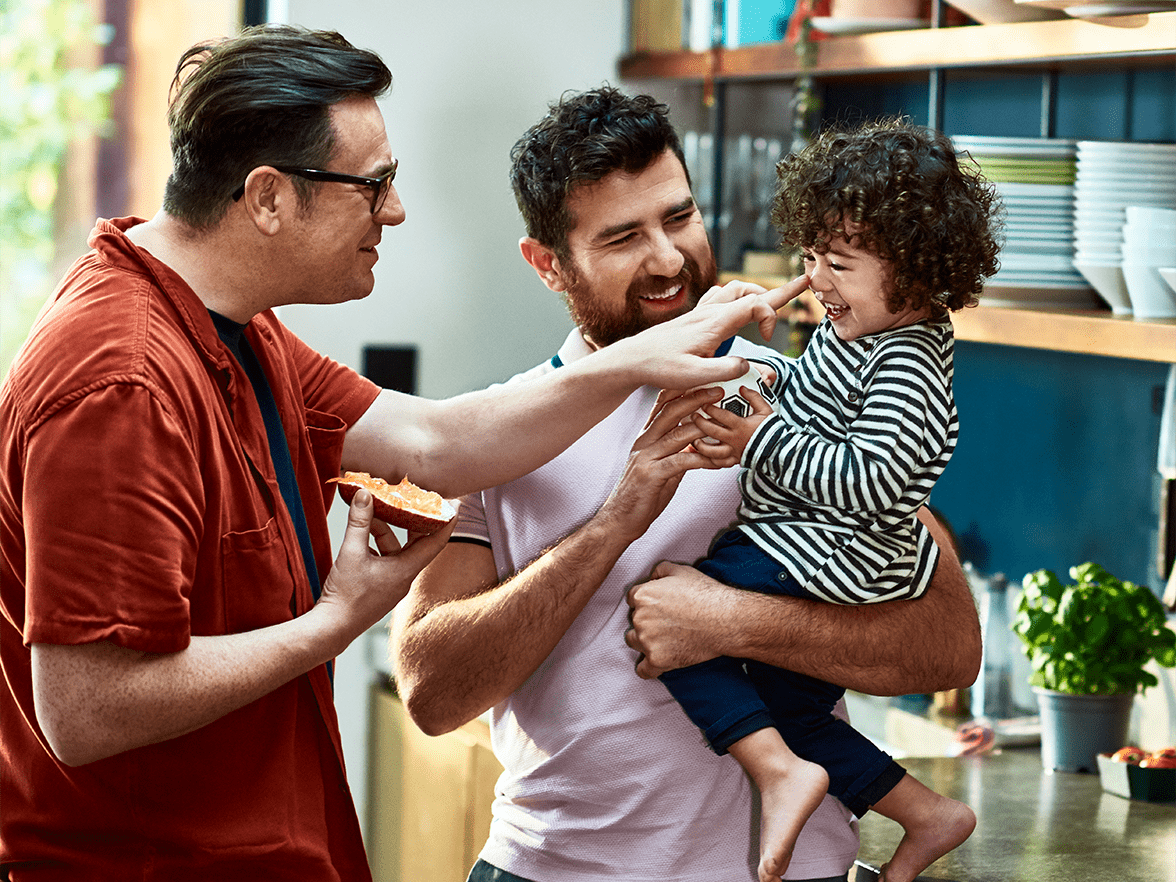 Two men holding a laughing child