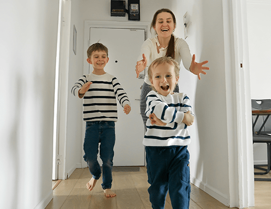 A woman running after her children in matching shirts