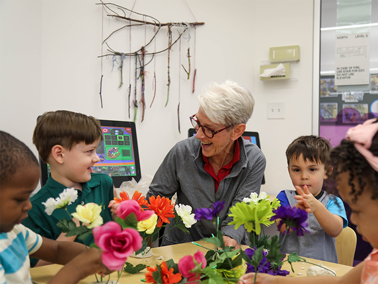 A child care teacher with a group of students at a table