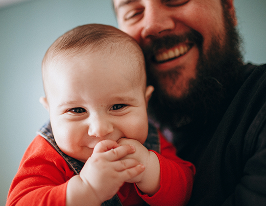 A man holding a smiling baby